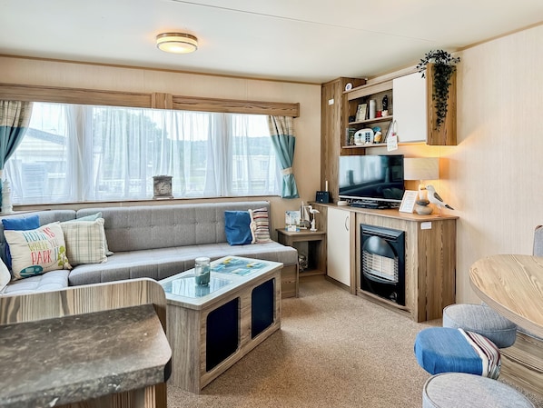 Un intérieur de camping-car accueillant, avec un canapé, une table basse et un coin cuisine.