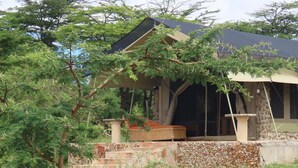 A house with a covered porch, stone steps, and a garden area. - Oseki Maasai Mara Camp-Affordable Glamping Tents Available Hosted by Maasai. (Sekanani Town)
