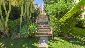 A garden with a stone staircase leading up to a building. - Cubo's Tennis Paradise Duplex / air conditioning / free wifi / community tennis court (Mijas Costa)