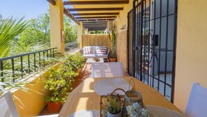A covered outdoor seating area with a table, chairs, and potted plants. - Cubo's Tennis Paradise Duplex / air conditioning / free wifi / community tennis court (Mijas Costa)