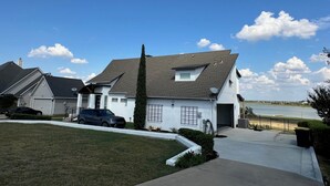 Una casa a un piano con tetto spiovente, un'antenna parabolica e un garage.