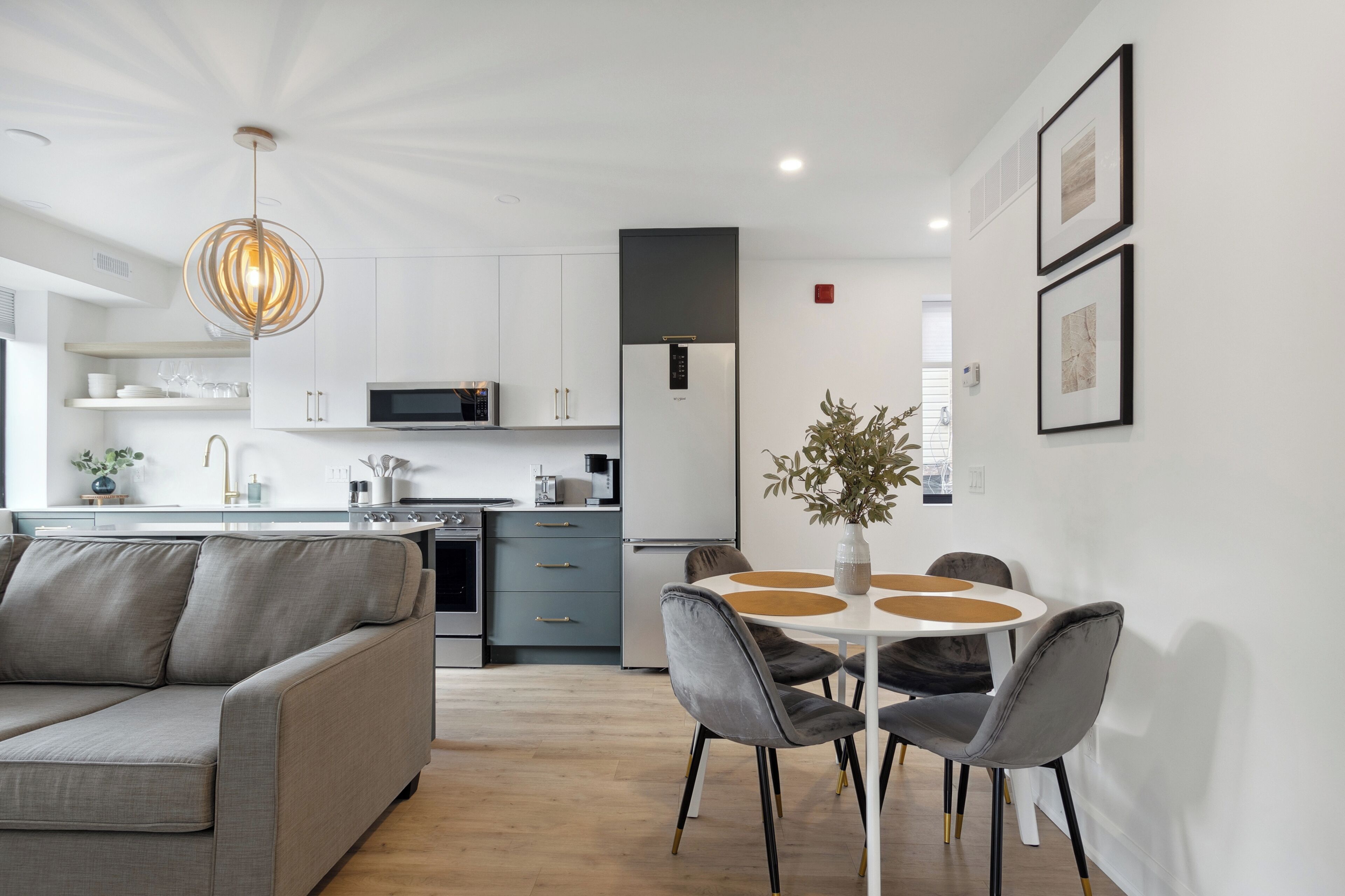 A modern kitchen with white cabinets, a built-in microwave, and a stainless steel refrigerator.