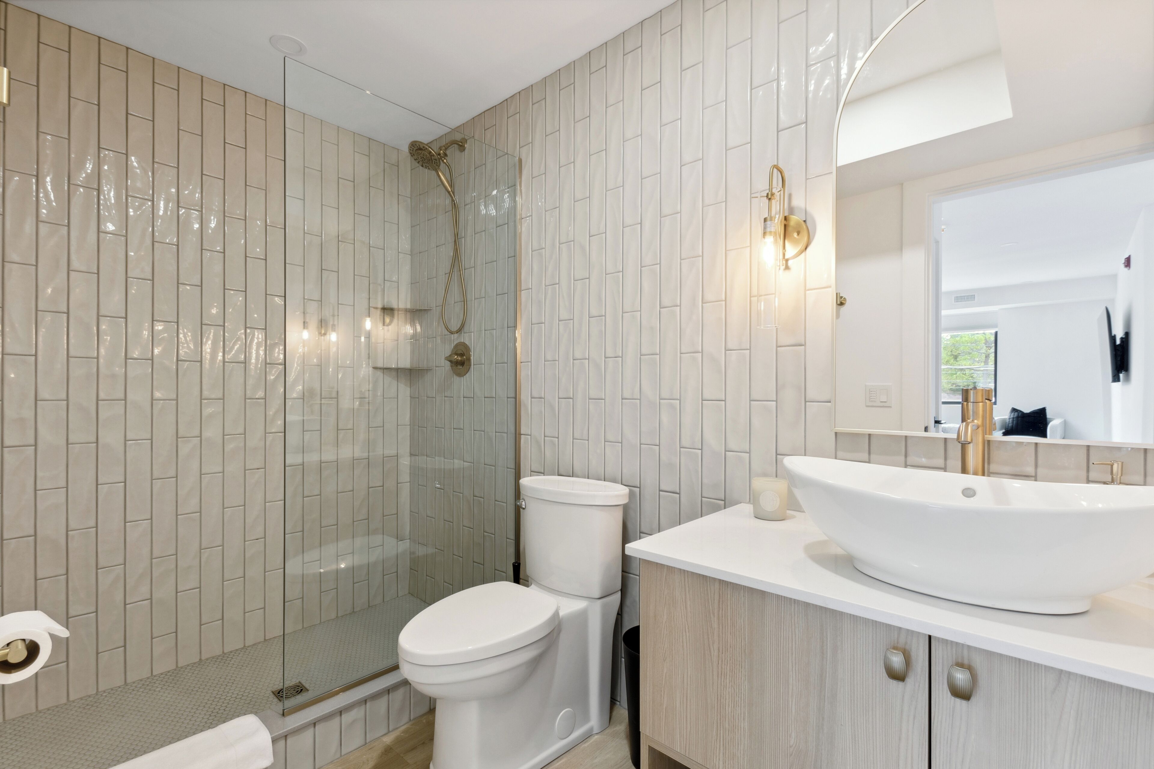 Une salle de bain moderne avec une douche à parois de verre, un lavabo blanc et des toilettes.