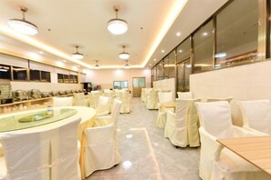 A banquet hall with round tables and chairs, a buffet area, and a large window. - Shanshui Trends Hotel (Sha Village MTR station store Guangzhou) (Guangzhou)