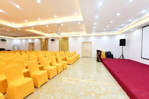 A conference room with rows of chairs, a stage, a projector, and a speaker. - Shanshui Trends Hotel (Sha Village MTR station store Guangzhou) (Guangzhou)