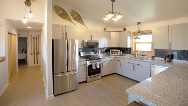 A modern kitchen with stainless steel appliances, white cabinets, and a granite countertop. -  4-bedroom get away with large kitchen, patio and backyard  (Carbondale)
