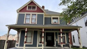 A two-story house with a porch and a front door.