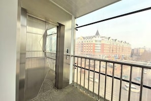 A balcony with a view of a building and a street. - Renhe Hotel (Heihe)