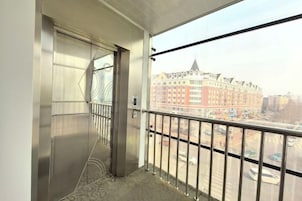 Un balcón con vista a un edificio y una calle.