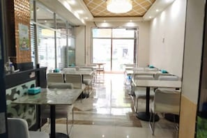 A restaurant with tables and chairs arranged for dining. - Renhe Hotel (Heihe)
