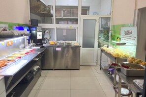 A buffet setup with various food items and a self-service beverage station. - Renhe Hotel (Heihe)