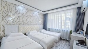 Una habitación de hotel con dos camas, un escritorio y una televisión.