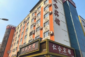 A multi-story building with signage indicating it is a hotel. - Renhe Hotel (Heihe)