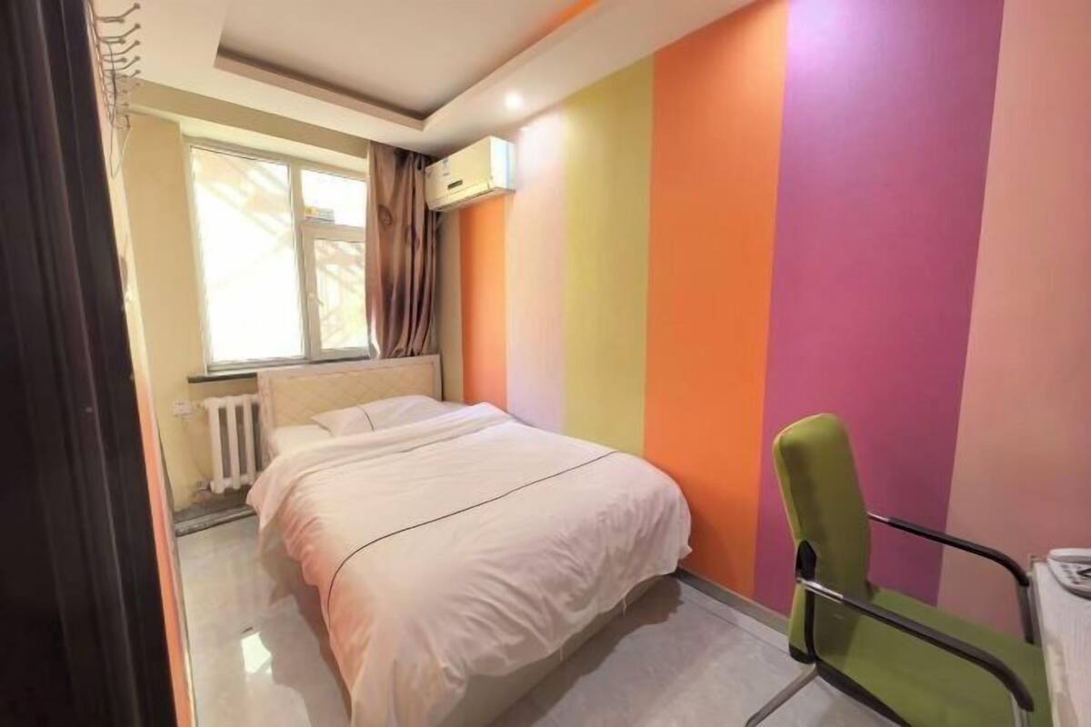 Ein Schlafzimmer mit einem Bett, einem Sessel, einer Heizung und einem Fenster.