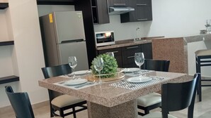A modern kitchen with dark cabinets, a built-in microwave, and a granite countertop. - Ankara Pedregal Centro de Convenciones (San Luis Potosi)