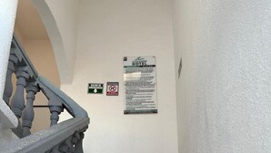 Un escalier avec une rampe et un panneau sur le mur.
