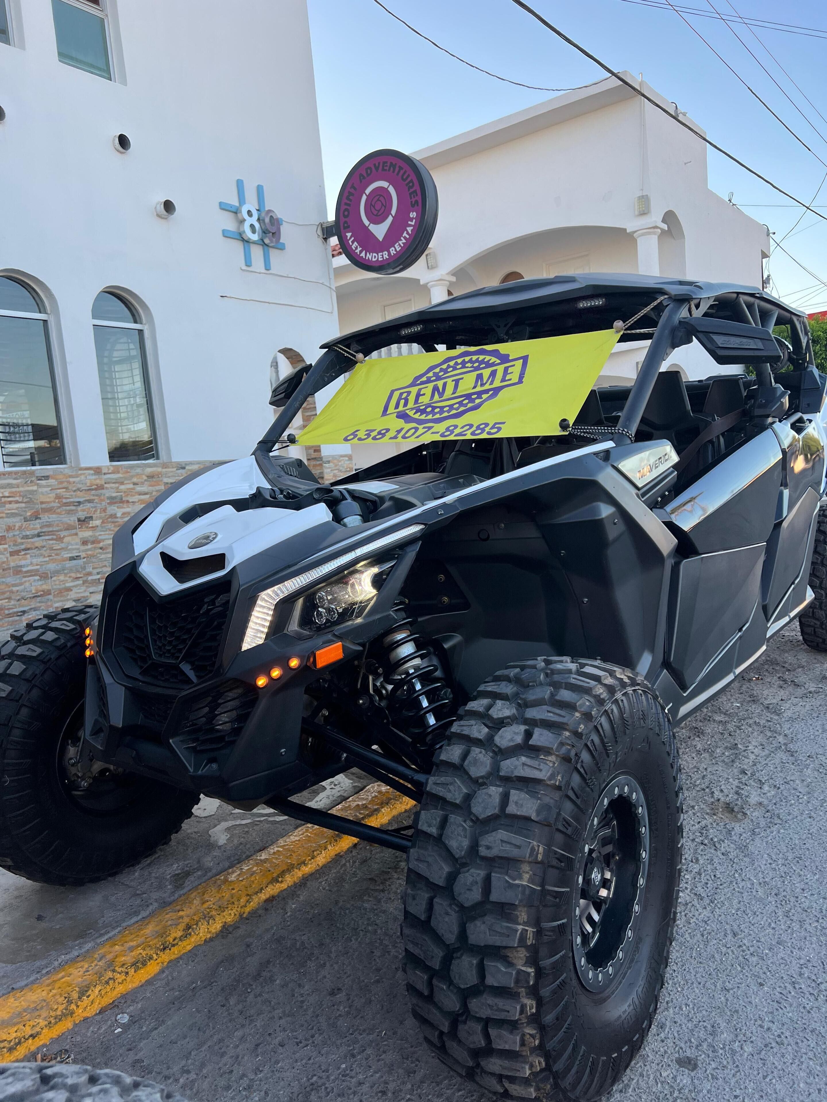 Un veicolo fuoristrada nero parcheggiato di fronte a un edificio con un cartello che riporta la scritta 'POINT ADVENTURES ALEXANDER RENTALS'.