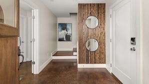 Un couloir doté d’un plancher en bois, de murs blancs et de deux portes.