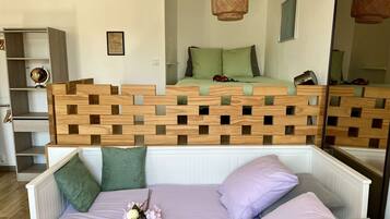 Un dormitorio con cama de altillo, cabecera de madera, un espejo y un globo terráqueo en un estante.