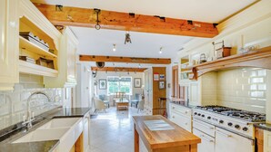 Una cocina con una mesa de madera, una estufa y armarios.