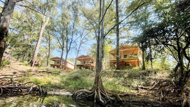 A serene lakeside setting with two wooden cabins surrounded by trees. - Paddlewhack Cabin 3-The Keel/Pet Friendly (Jefferson)