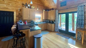 A spacious kitchen with wooden cabinets, a central island, and a large window providing natural light. - Chase N' Sunsets - NEW Listing, Brow view, between Mentone & Little River Canyon (Fort Payne)