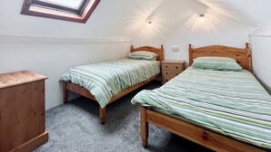 A dormitory room with two wooden beds, a small wooden dresser, a skylight, and two wall-mounted lights. - 3 bedroom accommodation in East Orchard, near Shaftesbury (East Orchard, near Shaftesbury)