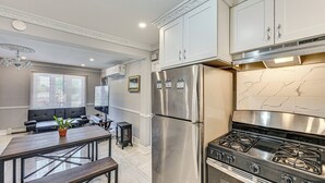 A modern kitchen with a stainless steel refrigerator, a gas stove, and white cabinetry. - Pet-Friendly Valley Stream Duplex - 1 Mi to Mall! (Valley Stream)