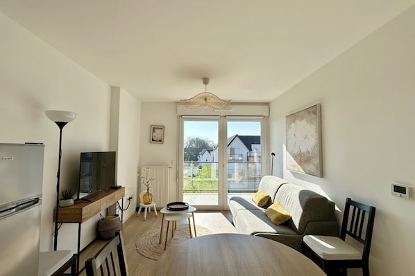 A compact living space with a dining area, kitchenette, and a sofa with a view to the outdoors. - Henson, apartment for 4 with balcony (Saint Valery sur Somme)