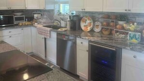 A modern kitchen with white cabinets, stainless steel appliances, and granite countertops. - Cozy keys getaway  (Ramrod Key)