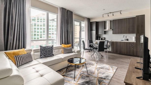 A modern living room with a sofa, coffee table, and dining area. - GLOBALSTAY. Stylish 1 Bedroom in Downtown Toronto (Toronto/Canada)