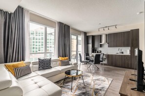 Un salon moderne avec un canapé, une table basse et un coin repas.