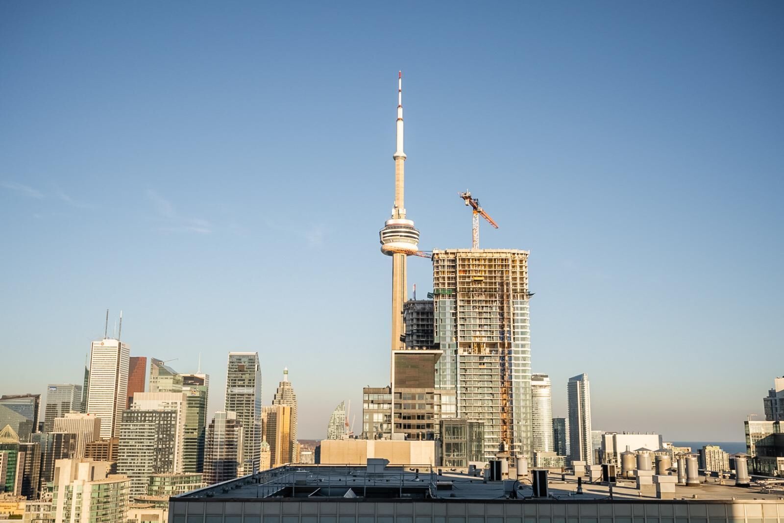 Une vue sur les toits d’une ville, avec une tour imposante et un bâtiment en construction.