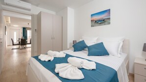 A hotel room with a bed, pillows, a painting, and a view of the beach. - 2 bedroom beautiful apartment in Podstrana (Podstrana)