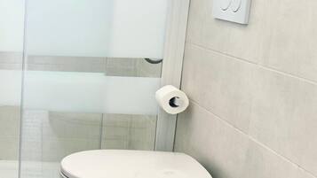 Een douche, een bidet, handdoeken