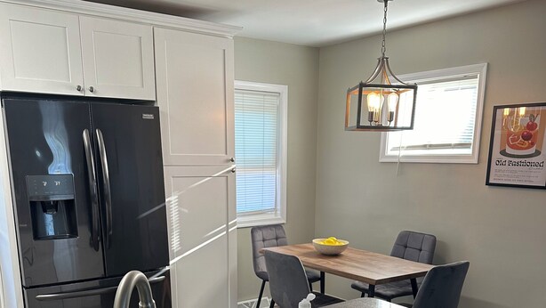 A kitchen with a stainless steel refrigerator, a sink with a faucet, a bottle of hand soap, and a remote control on the counter. - Charming 3-bedroom house with AC, WiFi in fabulous Bethlehem (Bethlehem)