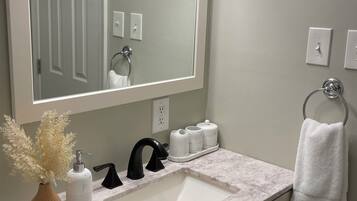 Een douche, handdoeken, zeep, shampoo