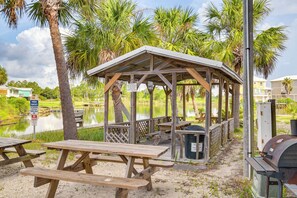 A wooden gazebo with picnic tables, a barbecue grill, and a sign indicating private property. - Gulf Shores Condo w/ Pool: Walk to Beaches! (Gulf Shores)