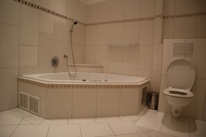 A bathroom with a bathtub, toilet, and shower.