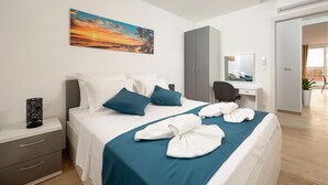 Une chambre d’hôtel avec un lit, un bureau, une armoire et un tableau au mur.