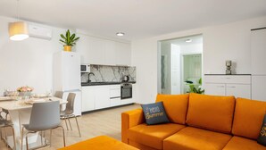 Un appartement moderne comprenant une cuisine, un coin repas et un salon.