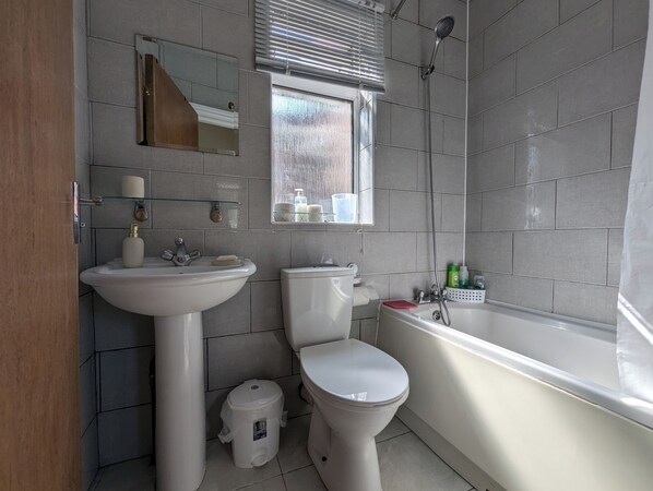 A bathroom with a sink, toilet, and bathtub.