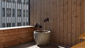 A potted plant on a balcony with a wooden floor and a wooden wall. - Luxury CBD townhouse 3 bed | 3 bath | 4 bed (Wellington)