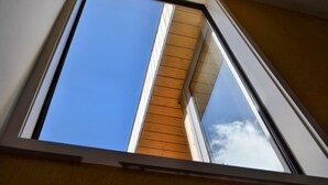 A skylight window with a clear view of the sky and a wooden beam structure. - Luxury CBD townhouse 3 bed | 3 bath | 4 bed (Wellington)