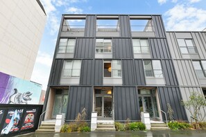 Un bâtiment moderne à la façade symétrique, doté de grandes fenêtres et d’une entrée centrale.