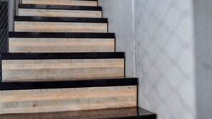 A staircase with wooden steps and black edges, leading up to a higher floor. - Luxury CBD townhouse 3 bed | 3 bath | 4 bed (Wellington)