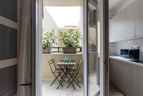 A kitchen with cabinets, a microwave, and a small table with chairs.