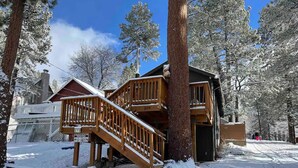 A wooden cabin with a staircase and a deck, surrounded by snow-covered trees. - Cozy Modern Cabin Near Lake, Spa, Village, & Ski Slope (Big Bear Lake)