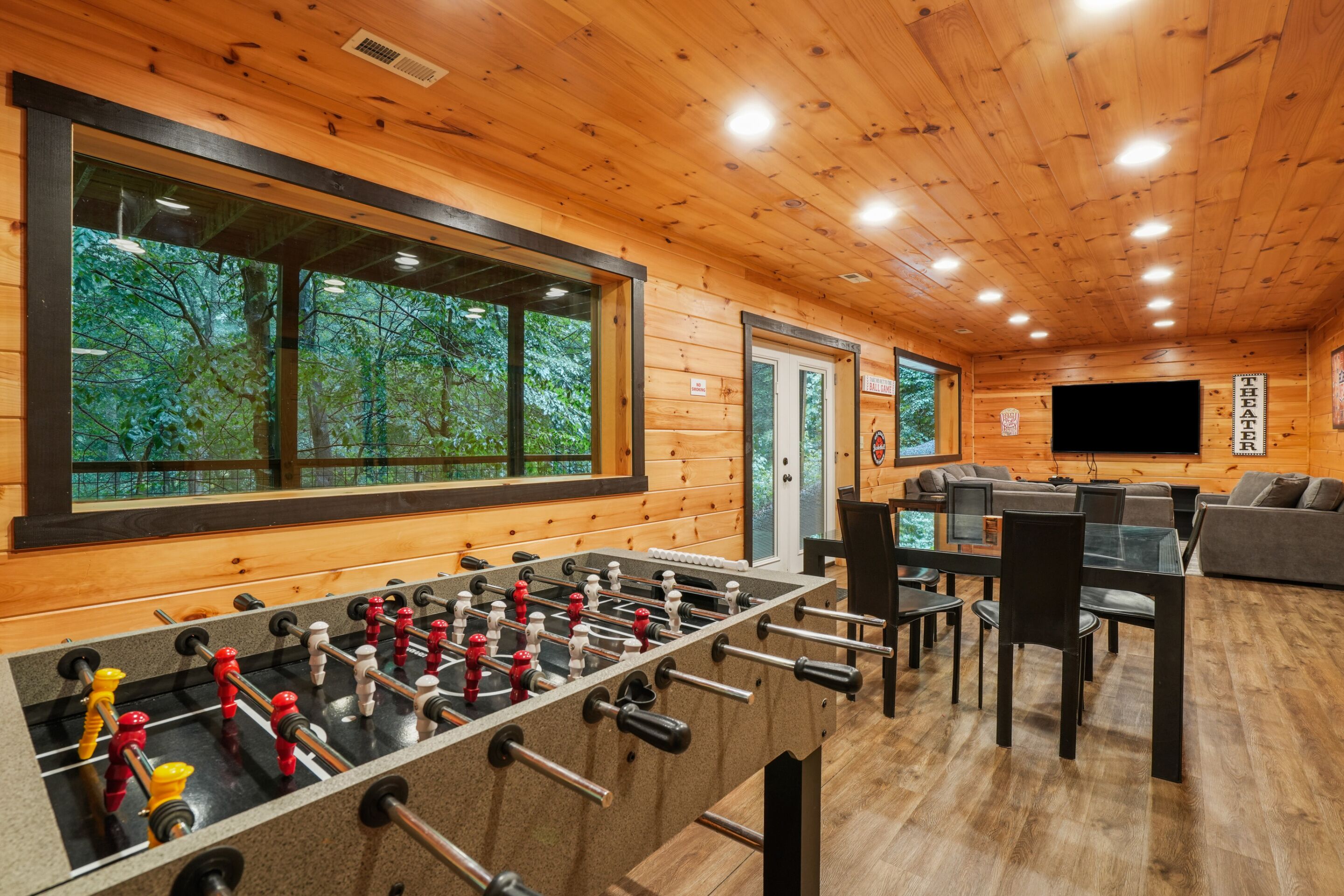 A cozy room with a foosball table, a sofa, and a TV.