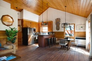Eine geräumige Küche mit Holzausstattung, einem Kühlschrank und einer Bar.